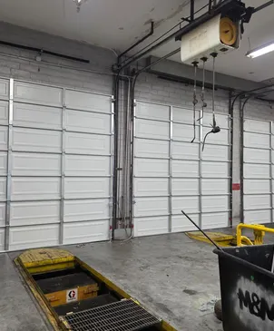 Commercial sectional door serviced in a shop bay