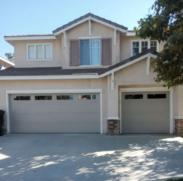 Two-story home with garage doors serviced by our team