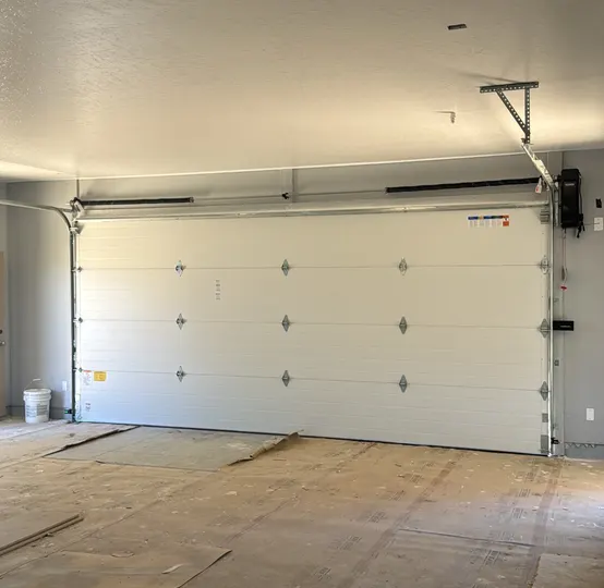 New insulated garage door installed inside a garage