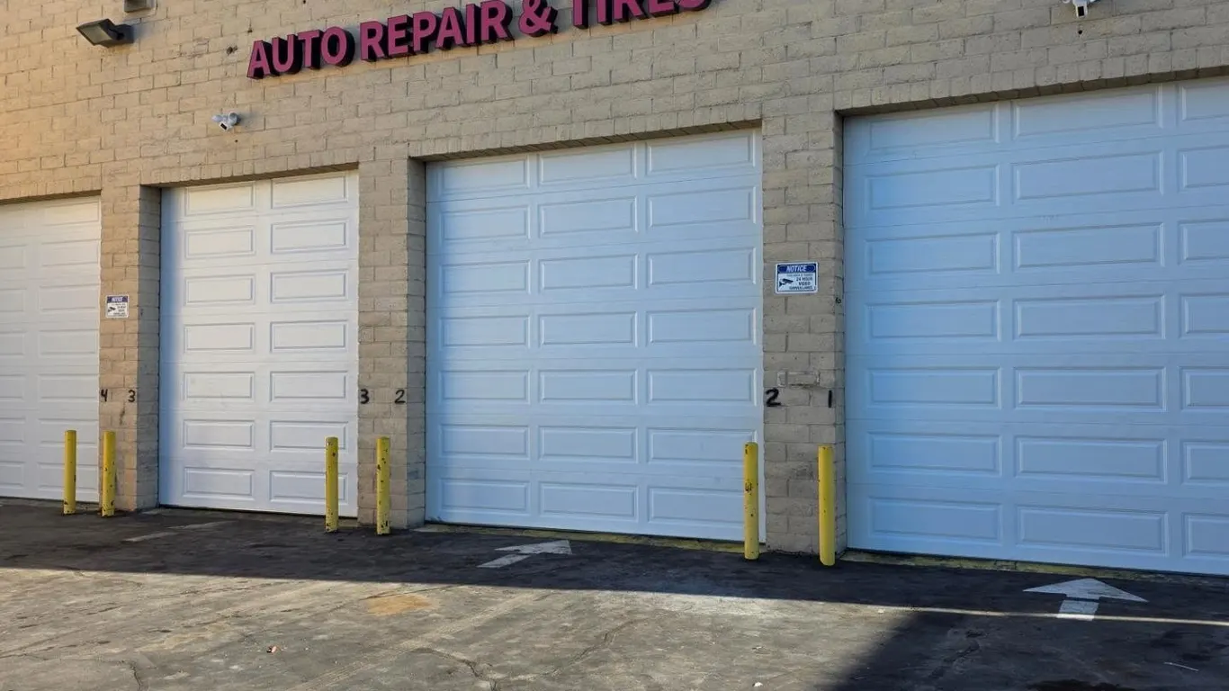 Three white sectional doors on an auto repair shop