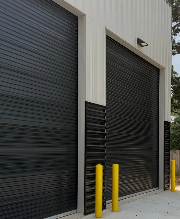 Black rolling steel doors on a two-tone warehouse