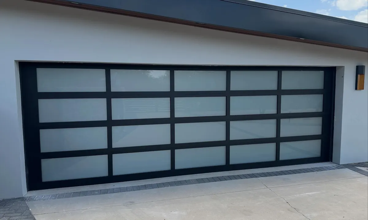 Black full-view aluminum garage door with frosted glass