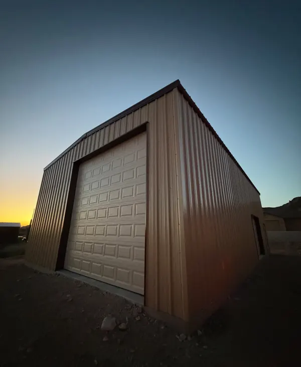 Service truck at a brown steel shop building at dusk