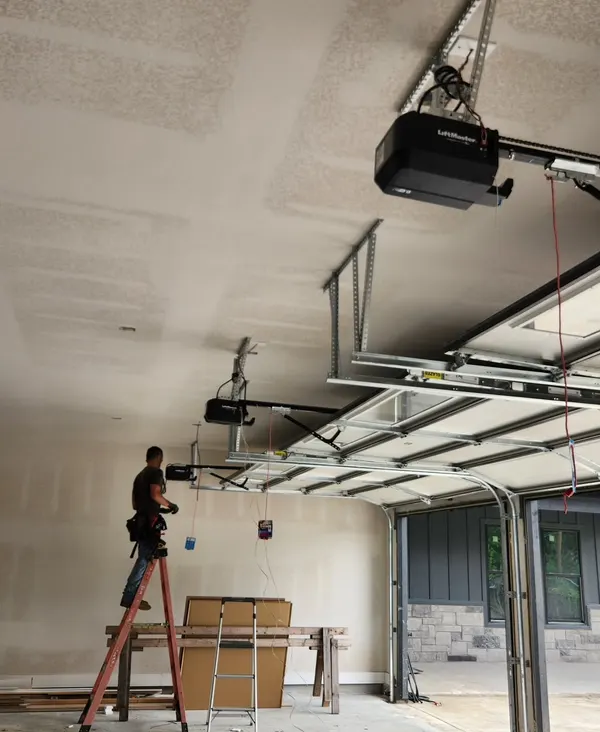 Technician installing a belt-drive garage door opener