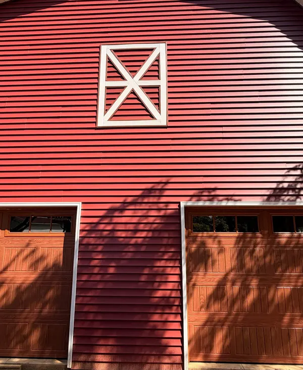 Red barn-style garage with two wood-look garage doors