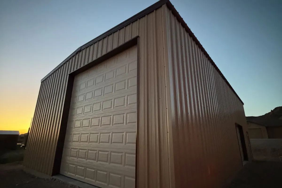 Steel shop building with a roll-up door at dusk