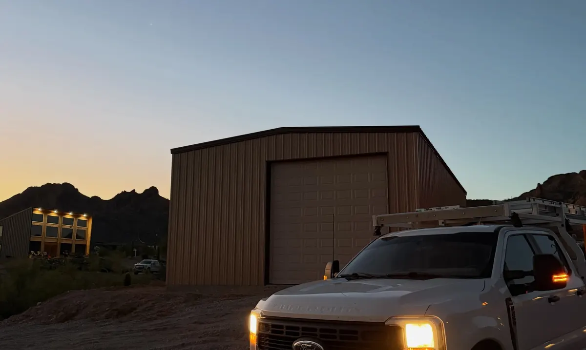 Service truck at a detached steel garage during an evening emergency call