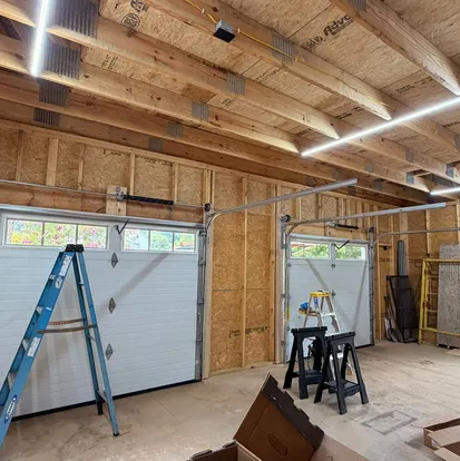 Technician servicing a garage door in a detached garage
