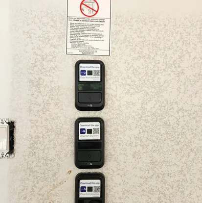 Wall-mounted garage door keypads and control consoles