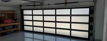 Belt-drive opener rail above a full-view glass garage door