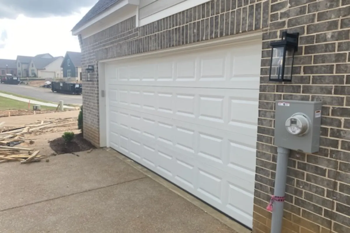 White sectional garage door on a brick home after repair