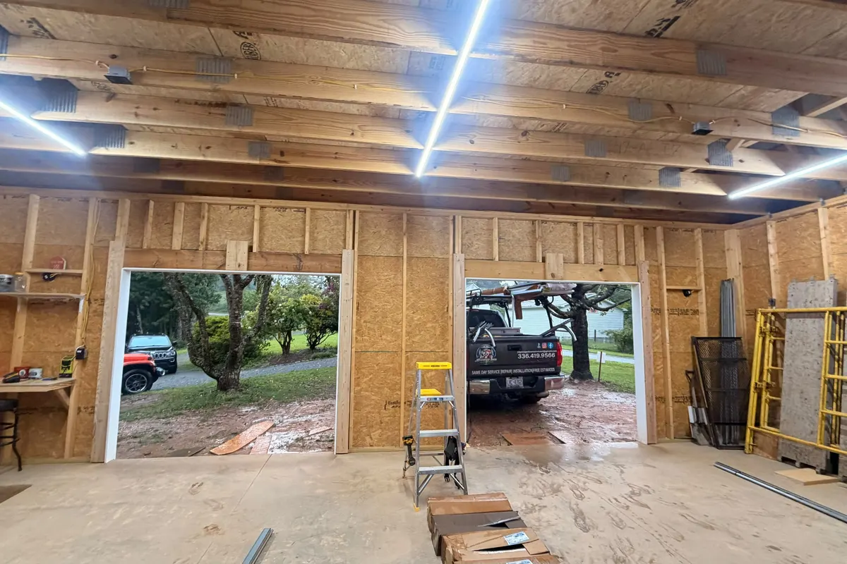 Open garage doors in a detached wood-frame garage