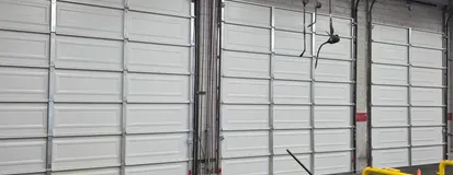 Sectional door tracks and rollers inside a commercial bay