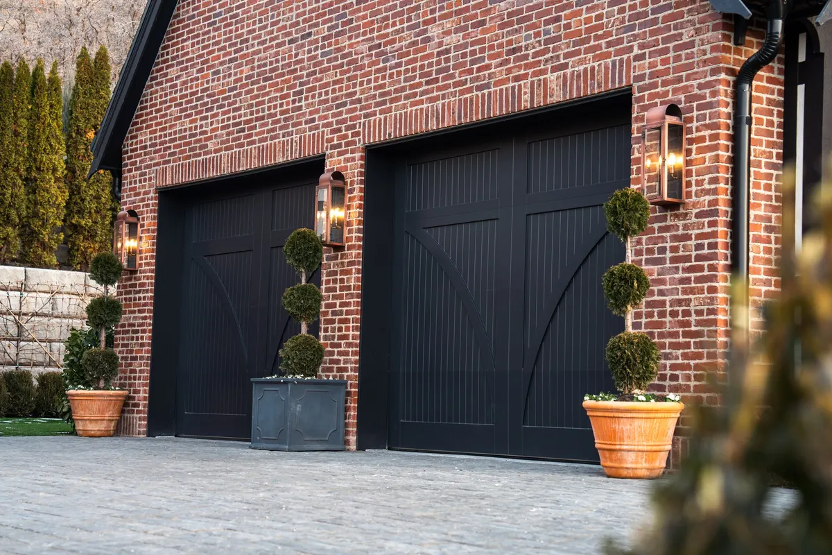 Black carriage-style single garage door after repair