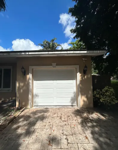 White single garage door on a home with palm trees
